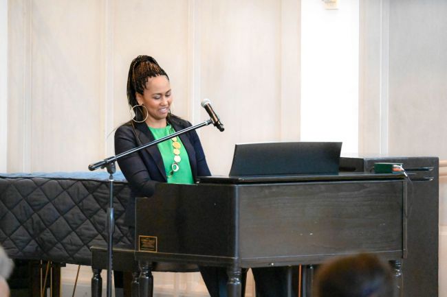 OBCS 2024 Sankofa Lecture; worship music; woman in green shirt playing piano
