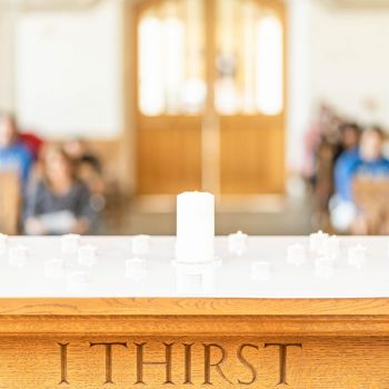 Candles on altar with "I thirst" carving